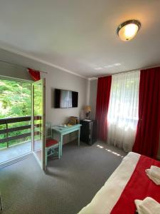 a hotel room with a bed and a desk and a window at Vila De Argint in Sinaia
