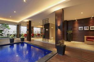 a swimming pool in the middle of a house at Ohana Hotel Kuta in Kuta