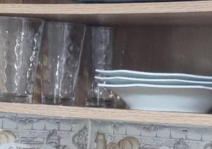 巴西利亚Kit Studio Asa Norte até 3 hospedes com WIFI sem taxas的架子上装有三瓶玻璃瓶和一碗