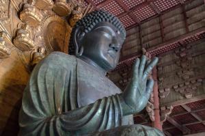 een groen standbeeld van helpende Boeddha in een gebouw bij Hotel Rokune in Nara