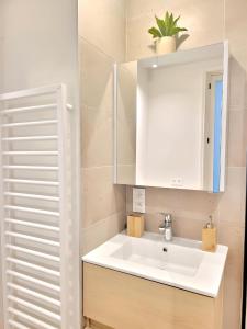 baño con lavabo y armario blanco en GRAND SABLON Stylish Brussels City Center Apartment, en Bruselas