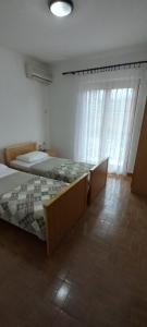 a bedroom with two beds and a large window at Apartments Budva Center in Budva