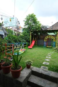 einen Hinterhof mit einem Spielplatz mit Rutsche in der Unterkunft Villa Jogja Syariah in Timuran