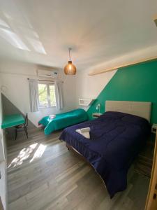 Un dormitorio con una cama azul y una pared verde en Departamento Céntrico en Termas de Río Hondo