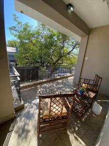un patio con 2 sillas y una mesa en el balcón en Departamento Céntrico en Termas de Río Hondo