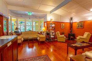 a living room with orange walls and yellow chairs at KUBBA ROONGA GUESTHOUSE - Boutique Luxury Peaceful Stay & Gardens - Bed & Breakfast in Blackheath