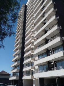 a tall white apartment building with balconies on it at Apartamento en Santiago. in Santiago