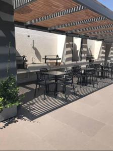 a group of tables and chairs on a patio at Apartamento en Santiago. in Santiago