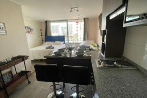 a living room with a kitchen and a room with a bed at Apartamento en Santiago. in Santiago