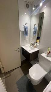 a bathroom with a white toilet and a sink at Apartamento en Santiago. in Santiago