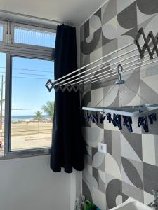a bathroom with a window with a view of the beach at Pé na areia, vista mar, wi-fi e varanda ! in Praia Grande +54 photos
