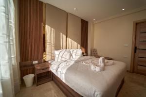 Un dormitorio con una cama con toallas blancas. en The Palace Pyramids Hotel en El Cairo