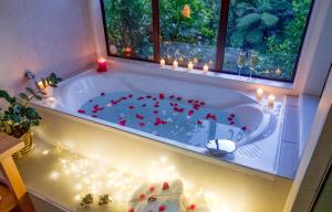 baño con bañera llena de corazones rojos en The Retreat - Luxury Hillside villa at Te Ngaere Bay en Kaeo