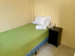 a small bed with a pillow and a night stand at Casa Quetzal in Guatemala