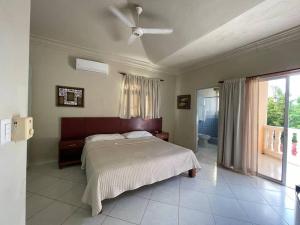 Schlafzimmer mit einem Bett und einem Deckenventilator in der Unterkunft Luxury Villa Classic style - 7 min. from the beach in San Felipe de Puerto Plata