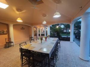 una grande sala da pranzo con un lungo tavolo e sedie di Luxury Villa Classic style - 7 min. from the beach a San Felipe de Puerto Plata