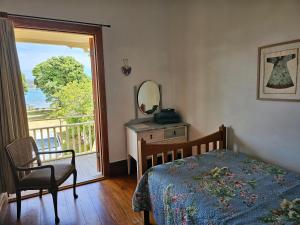 1 dormitorio con cama, espejo y ventana en Brony's Beachfront-Short and Long Term Stays, en Porirua