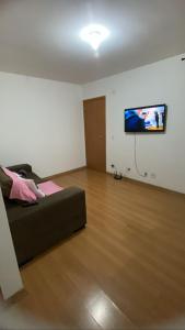 a living room with a bed and a flat screen tv at Apartamento Super Aconchegante em Ambiente Familiar in Contagem