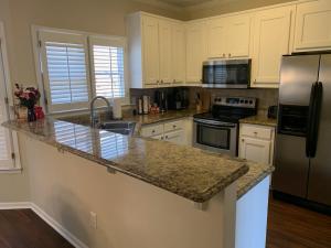a kitchen with white cabinets and a granite counter top at 2,298Sqft-King Bed-BBQ-Gbps-W/D in Snellville
