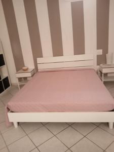 uma cama branca num quarto com um colchão rosa em Casa Lavinia al mare em Rimini
