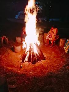 un gran fuego en el suelo con gente alrededor en Lilly's Valley Resort en Kodaikānāl