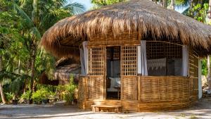 una capanna con tetto di paglia su una spiaggia di Cayo Coco - Island Glamping All-Inclusive a Barangonan