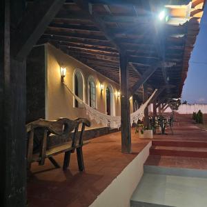 eine Holzbank unter einem Gebäude mit Lampen in der Unterkunft Pousada Casa Bella in Itaberaba