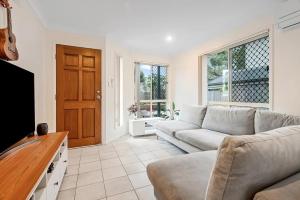 a living room with a couch and a tv at Luxurious Urban Eco Escape 3br in Brisbane