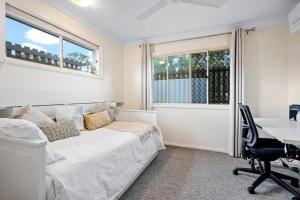 a bedroom with a bed and a desk and windows at Luxurious Urban Eco Escape 3br in Brisbane