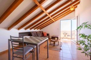 a dining room with a table and a couch at Apartment 1BR Hills over Ponta do Sol, sea view in Ponta do Sol +14 photos