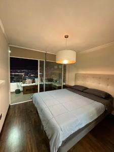 a bedroom with a large bed and a large window at Departamento a pasos de PLAYA BRAVA! Cavancha in Iquique