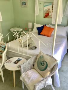 1 dormitorio con 2 camas y 1 silla en Azalea Bed and Breakfast Hideaway, en Tura Beach