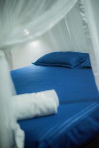 a bed with blue sheets and blue pillows on it at Milla Resort in Buttala
