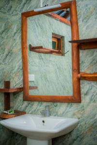 a bathroom with a mirror and a sink at Milla Resort in Buttala