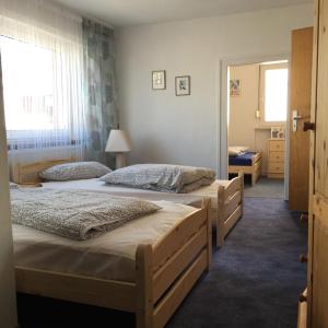 two beds in a room with two windows at Apartment Hope Inn in Groß-Zimmern