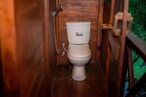 a bathroom with a toilet in a wooden room at Milla Resort in Buttala