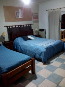 a bedroom with two beds with blue comforter at La Casona de Susana in Colón
