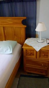 a bedroom with a bed and a nightstand with a lamp on it at La Casona de Susana in Colón