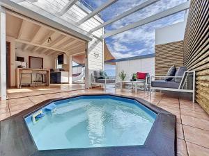 an indoor swimming pool in a house with an open ceiling at Terrathely in Le Moule