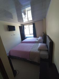 Cette chambre comprend 2 lits et une fenêtre. dans l'établissement HOTEL EL GRAN CASINO ESMERALDA, à Barbosa