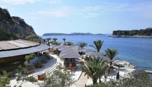 a restaurant with umbrellas on a beach next to the water at Apartments Villa Sirena in Dubrovnik +63 photos
