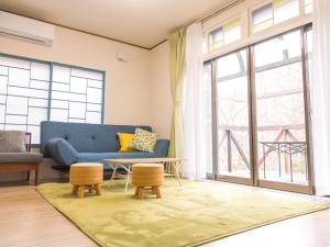 a living room with a blue couch and a large window at PEDAL TERRACE in Iida +49 photos