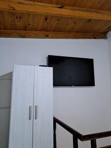 um armário branco com uma televisão de ecrã plano na parede em La Guanaca em Perito Moreno
