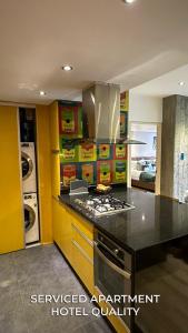cocina con paredes amarillas y horno con fogones en Serviced Apartment Pretty Penthouse Valencia, en Valencia
