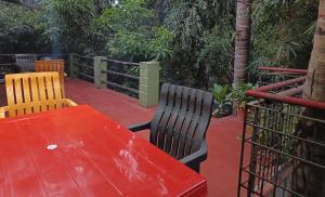 a red table and two chairs on a patio at LOTUS RIYA Homestay in Hampi