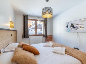 a bedroom with a large bed with pillows on it at Charmant appt de 41m² au cœur du Vieil Alpe, proche pistes, idéal pour 4 pers, tout confort, WiFi inclus - FR-1-645-67 in LʼHuez