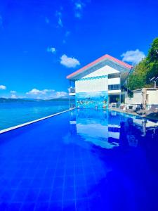 una piscina con un edificio vicino all'acqua di Coron Underwater Garden Resort a Coron