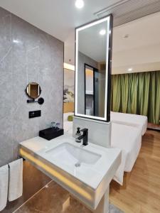 a bathroom with a white sink and a mirror at Connar Hotel - Shenzhen Futian in Shenzhen