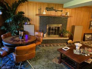 ein Wohnzimmer mit einem Tisch und einem Kamin in der Unterkunft Whole Home MidCentury - Quiet & Close to Downtown in Des Moines
