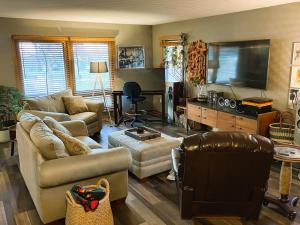 ein Wohnzimmer mit 2 Sofas und einem Flachbild-TV in der Unterkunft Whole Home MidCentury - Quiet & Close to Downtown in Des Moines